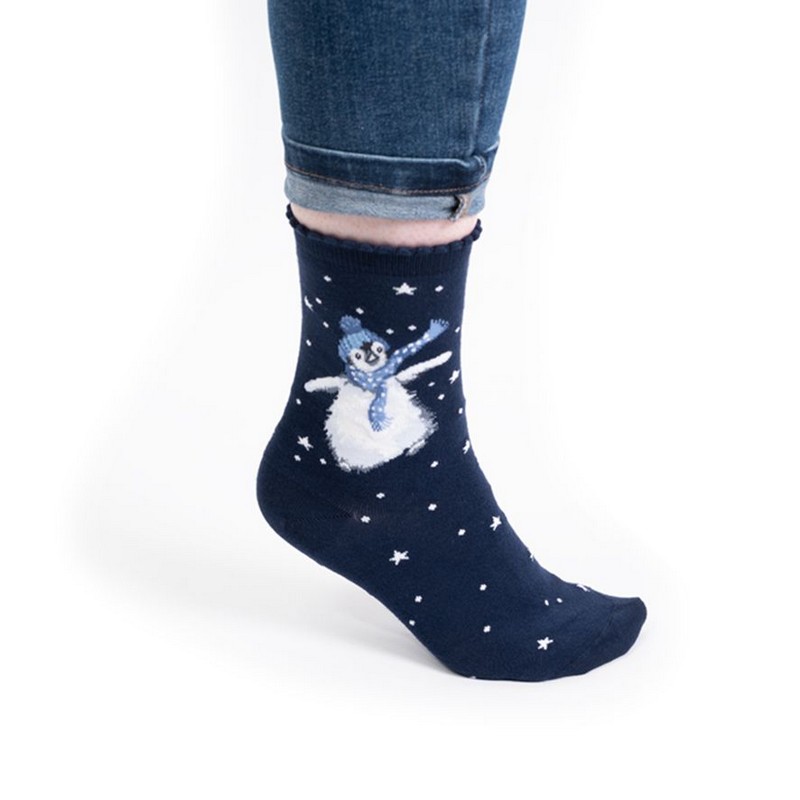 Calze natalizie da donna decorate con un pinguino con sciarpa e cuffia su sfondo indaco