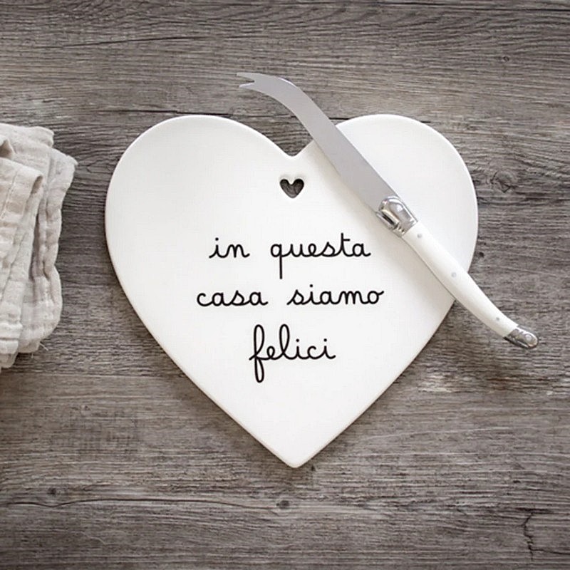 Sottopentola in gres bianco a forma di cuore decorato con scritta “In questa casa siamo felici”, con base antiscivolo