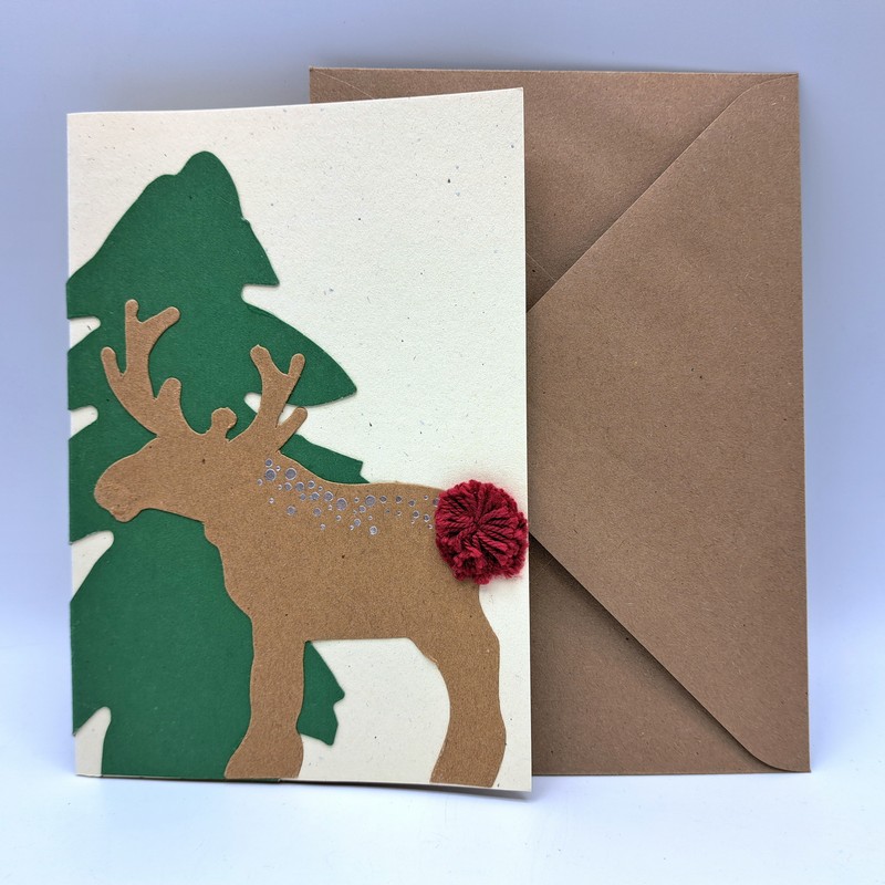Biglietto di Natale fatto a mano da noi decorato con renna nel bosco con coda pompon e busta inclusa, ideale da abbinare ai tuoi regali di Natale!