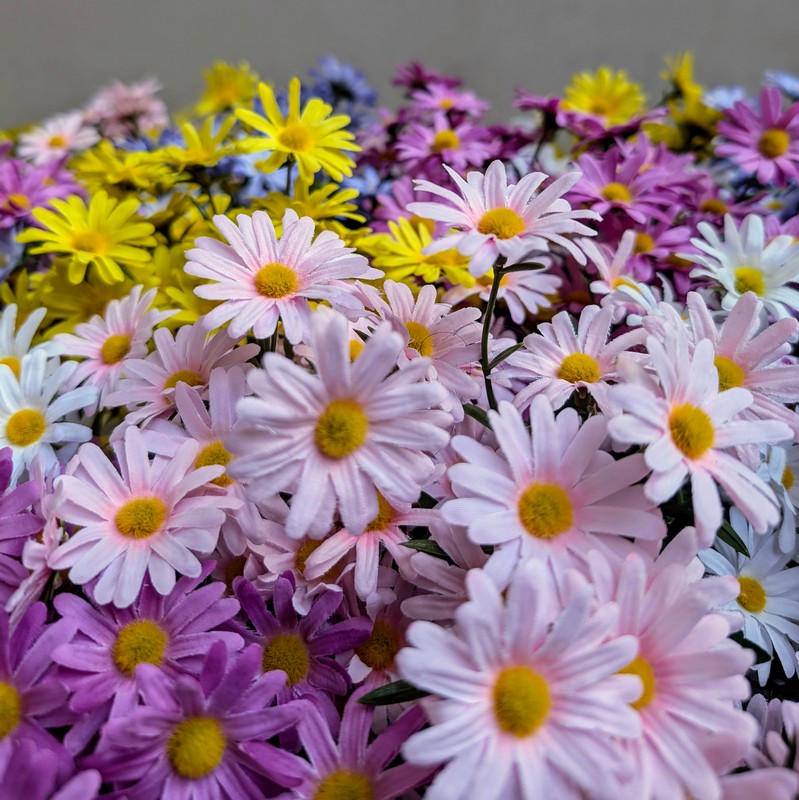 Cespuglio di fiori artificiali con margherite rosa e foglie