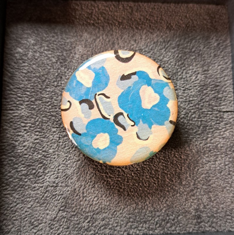 Anello regolabile in legno di tiglio e ottone satinato decorato con fiori blu su fondo beige, fatto a mano in Italia