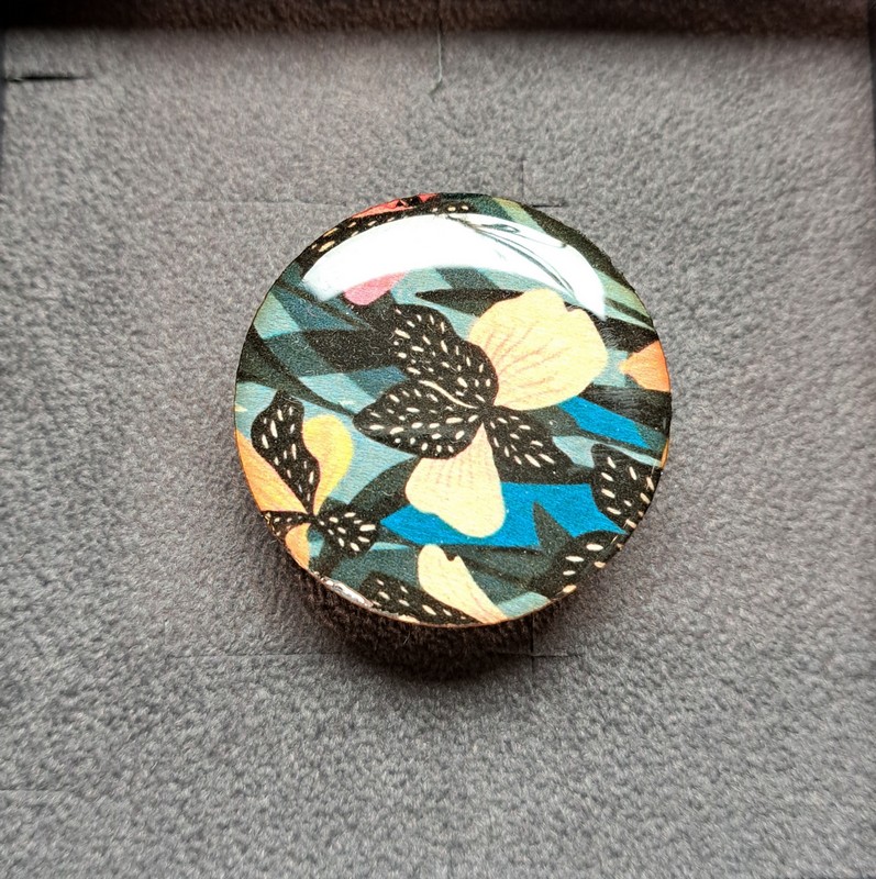 Anello regolabile in legno di tiglio e ottone satinato decorato con fiori neri con dettagli beige, arancioni e verdi, fatto a mano in Italia