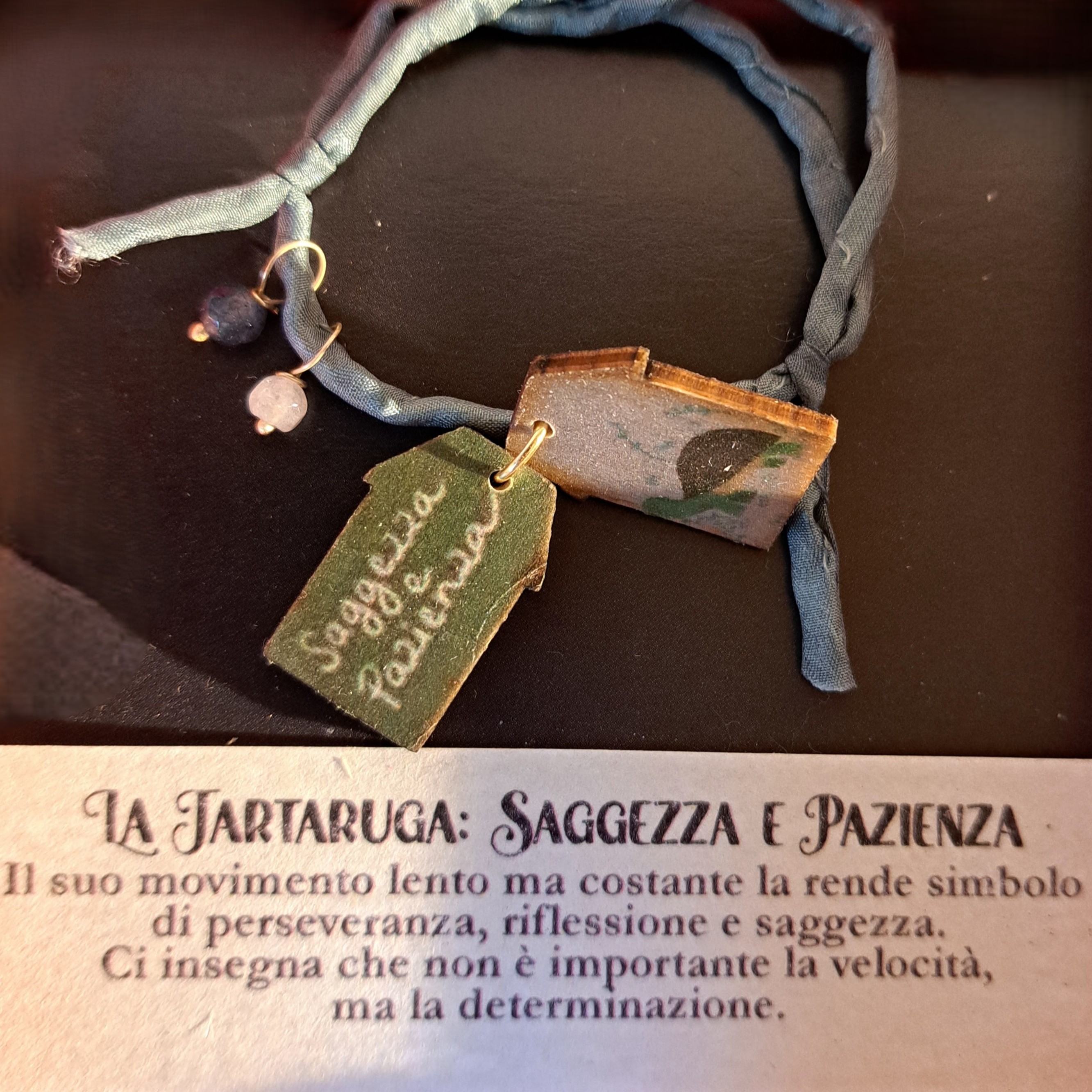 Braccialetto in seta decorato con pietre e casette di legno laccato raffiguranti una tartaruga con dedica “Saggezza e pazienza”, fatto a mano in Italia