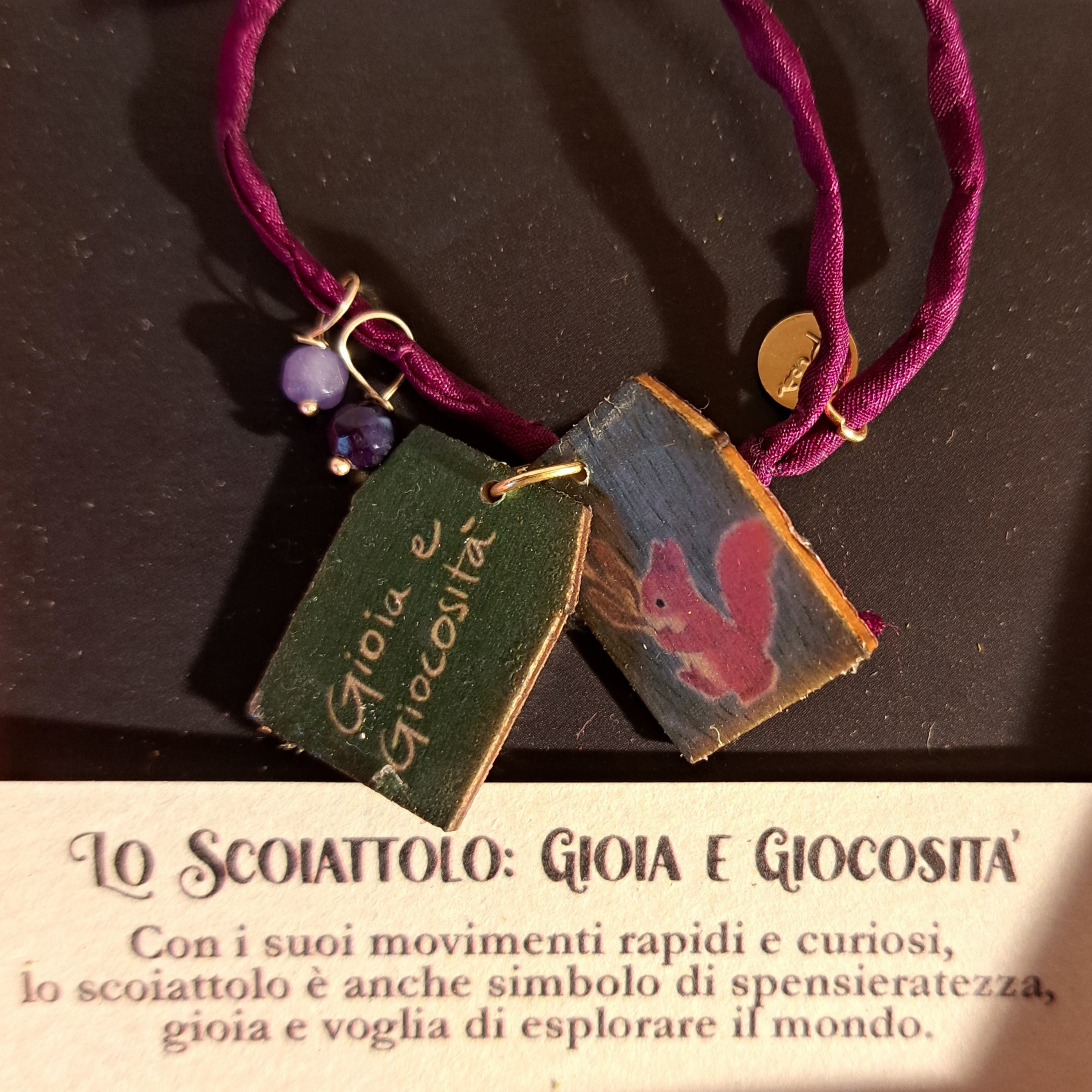 Braccialetto in seta decorato con pietre e casette di legno laccato raffiguranti uno scoiattolo con dedica “Gioia e giocosità