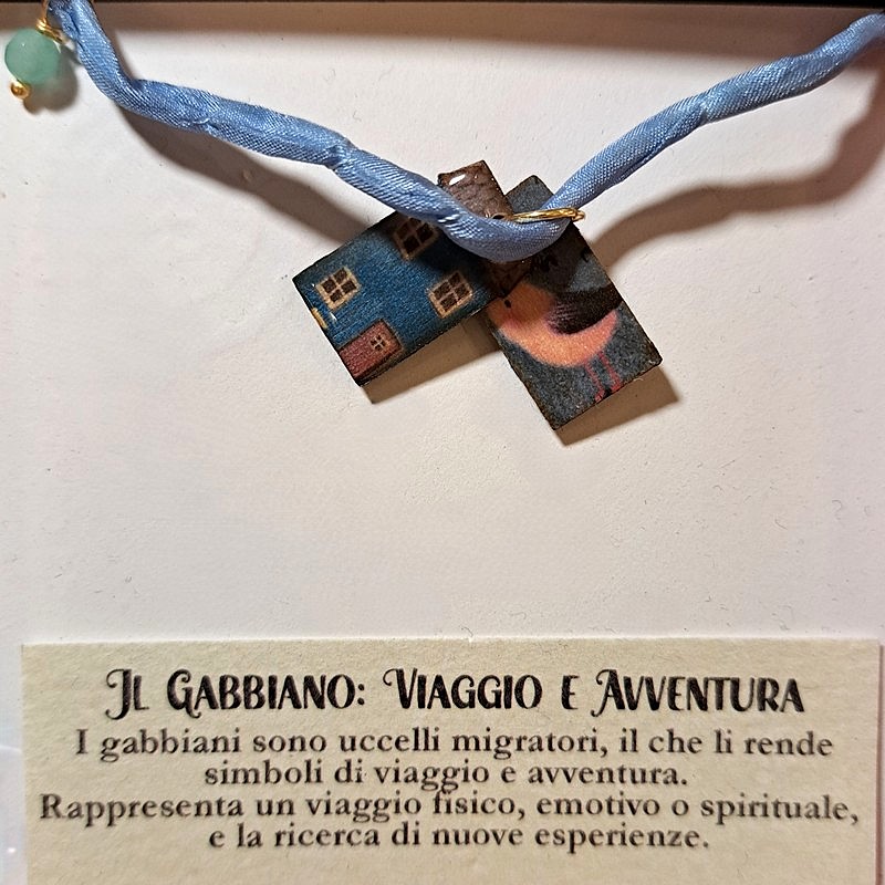 Braccialetto in seta decorato con pietre e casette di legno laccato raffiguranti un gabbiano con dedica “Viaggio e avventura