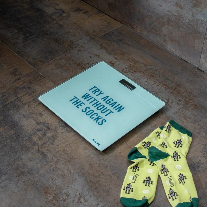 Bilancia pesa persone azzurra con scritta “Try again without the socks” e termometro