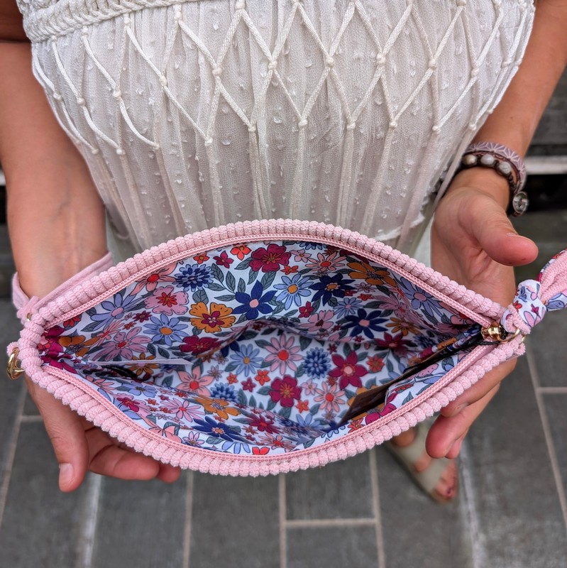 Pochette in velluto a costine rosa con interno floreale, chiusura a zip