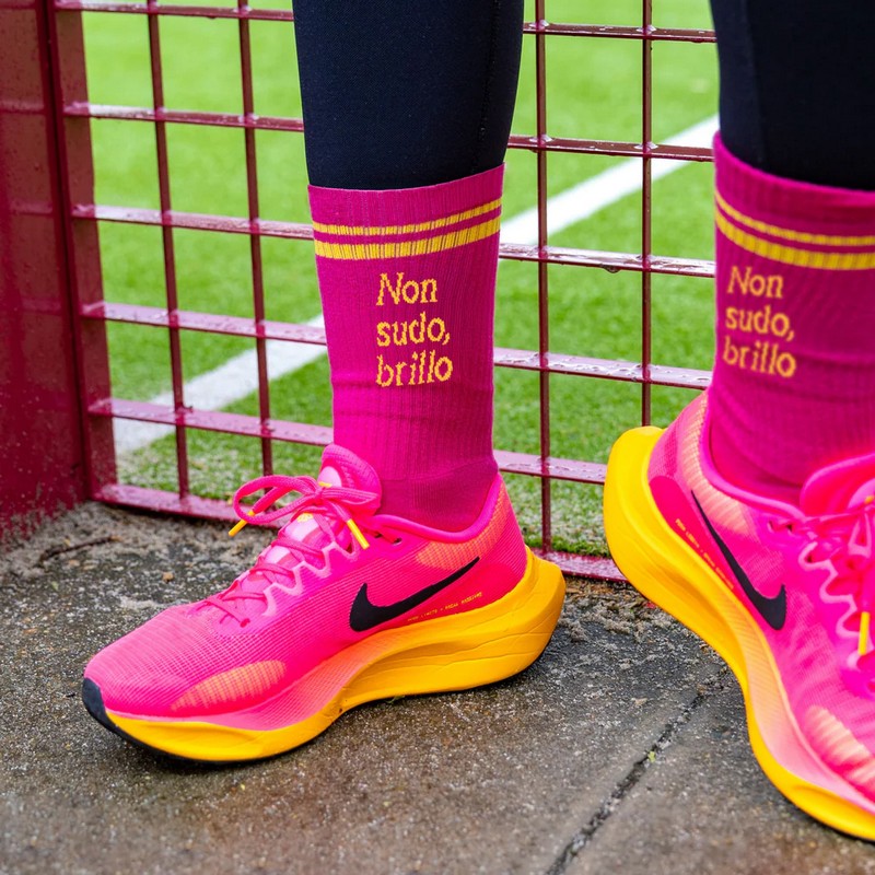 Paio di calze rosa e gialle sportive decorate con scritta “Non sudo, brillo”