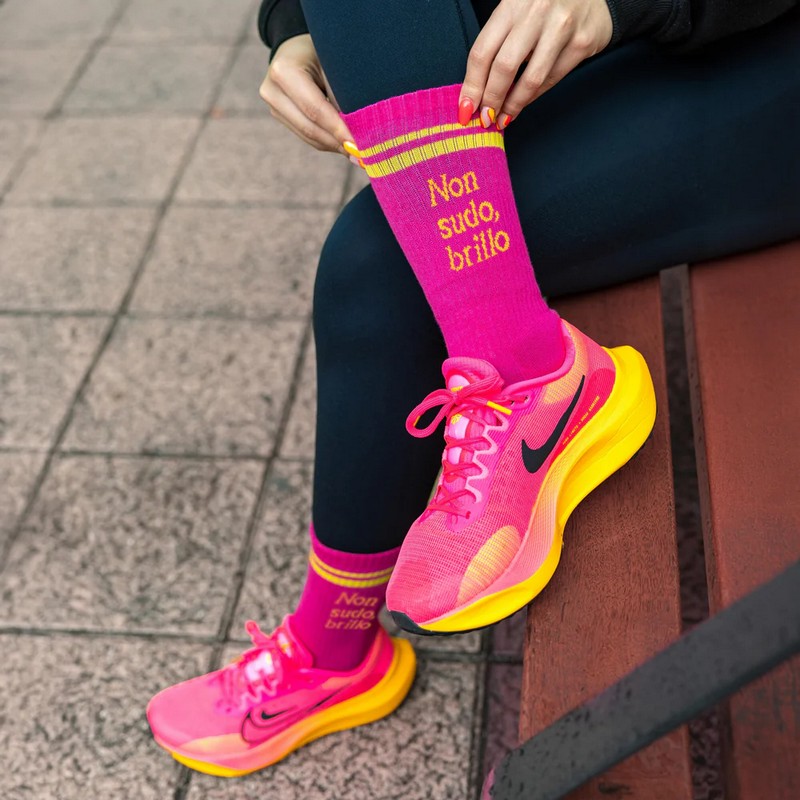Paio di calze rosa e gialle sportive decorate con scritta “Non sudo, brillo”