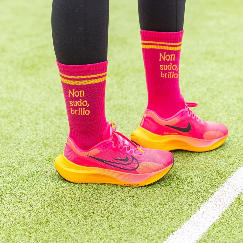 Paio di calze rosa e gialle sportive decorate con scritta “Non sudo, brillo”