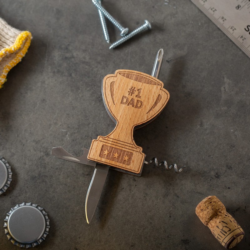 Gadget multiattrezzo 5 in 1 con rivestimento in legno a forma di trofeo e scritta “Papà numero 1” (#1 Dad), include cacciavite piatto e a stella, apribottiglie, coltellino e cavatappi