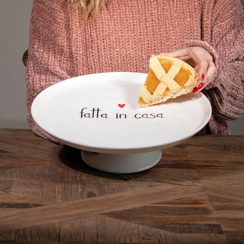 Alzata per dolci e torte in ceramica bianca decorata con scritta “Fatta in casa”, con cuore rosso e bordo rialzato, ideale come regalo per appassionati di dolci