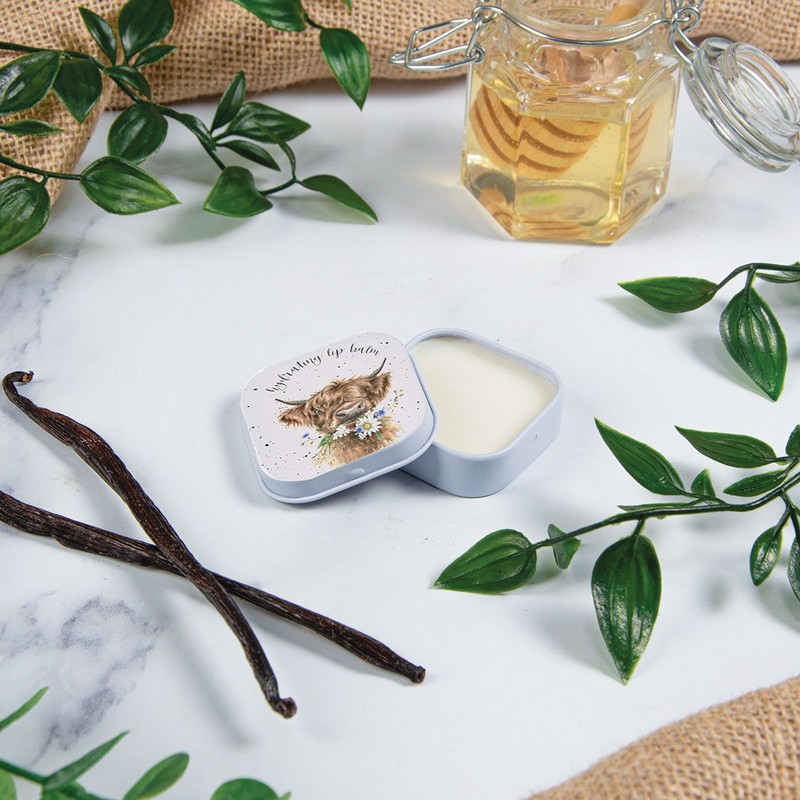 Balsamo per labbra al profumo di miele e vaniglia contenuto in scatola di latta decorata con mucca Highlander