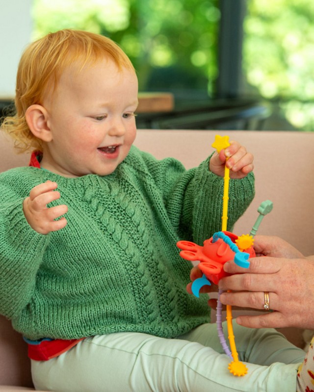 Gioco multisensoriale tattile a forma di pianeta rosso per bambini con appendici rigate e pulsanti