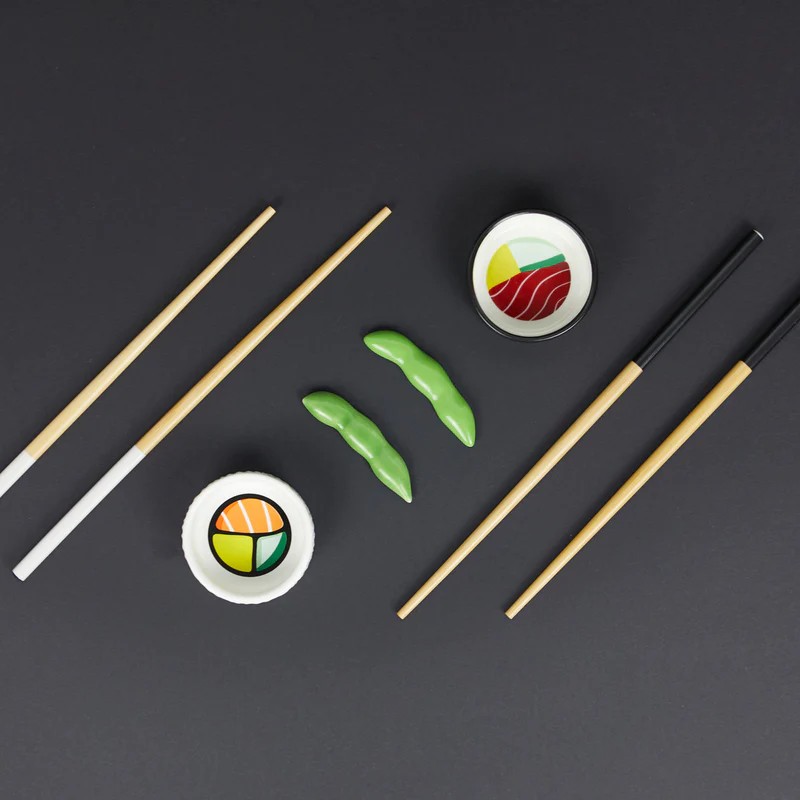 Set sushi contenente due paia di bacchette in bambù, due poggiabacchette a forma di edamame e due ciotoline per condimenti in ceramica, il tutto contenuto in un cofanetto