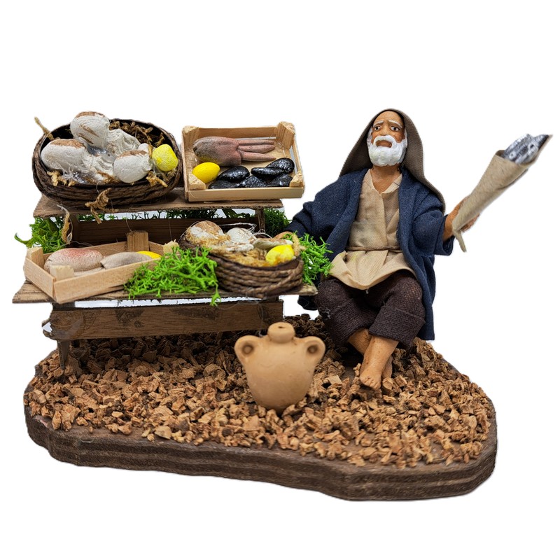 Pescivendolo anziano con banco con su pesci, personaggio del presepe napoletano, prodotto artigianale della città metropolitana di Napoli fatto a mano e dipinto a mano