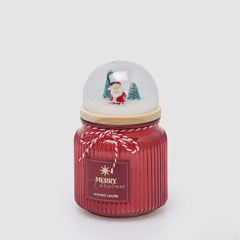 Candela in vetro rosso profumata al sidro di mele con miele, con coperchio a forma di cupola con paesaggio natalizio in legno, neve e campanelle