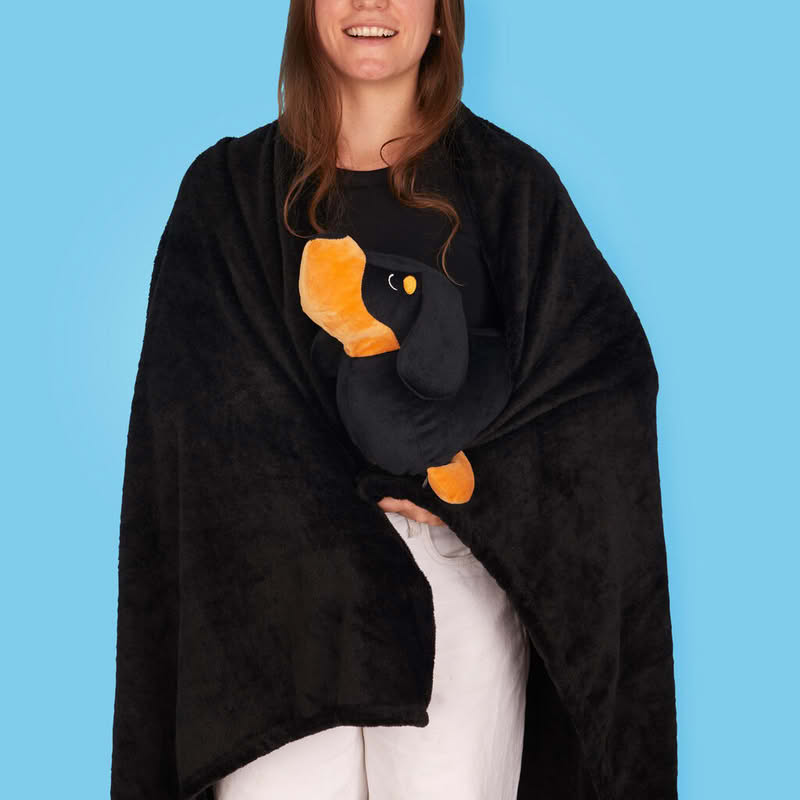 Cuscino a forma di bassotto nero e marrone con al suo interno una coperta dello stesso colore di dimensione 150 x 110 cm, il tutto è lavabile in lavatrice