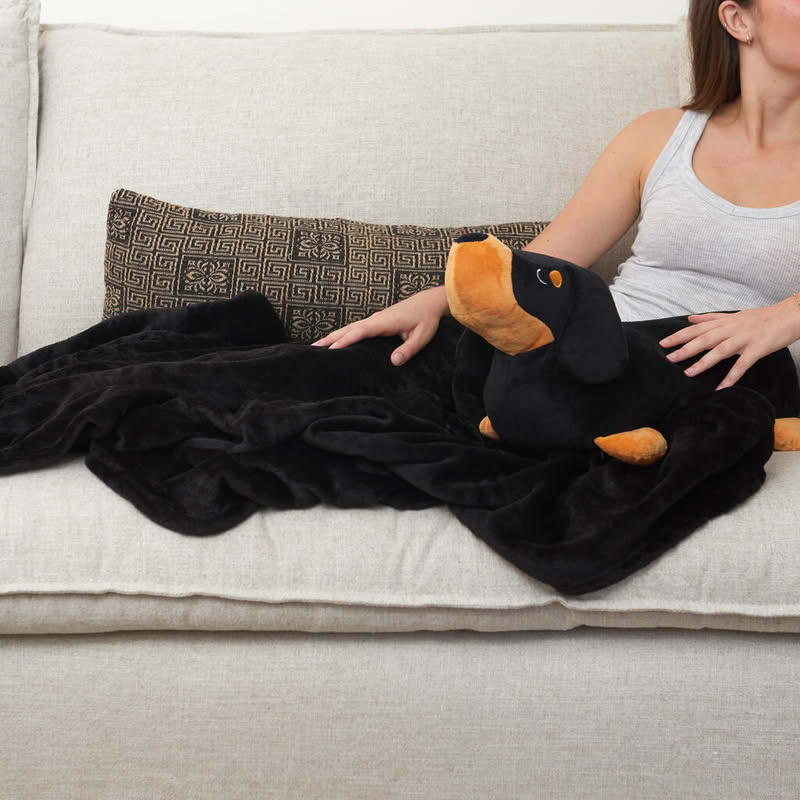 Cuscino a forma di bassotto nero e marrone con al suo interno una coperta dello stesso colore di dimensione 150 x 110 cm, il tutto è lavabile in lavatrice