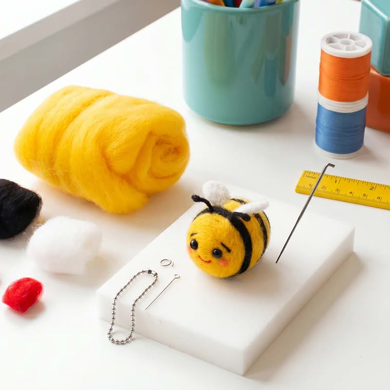 Kit di lana colorata, ago e tappetino per infeltrimento, occhi, anellino portachiavi e istruzioni per creare un'ape che può essere utilizzata come portachiavi