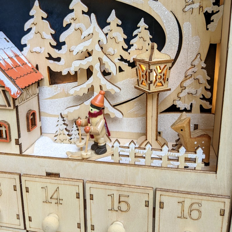 Calendario dell'avvento a forma di casetta in legno con cassetti e illuminazione