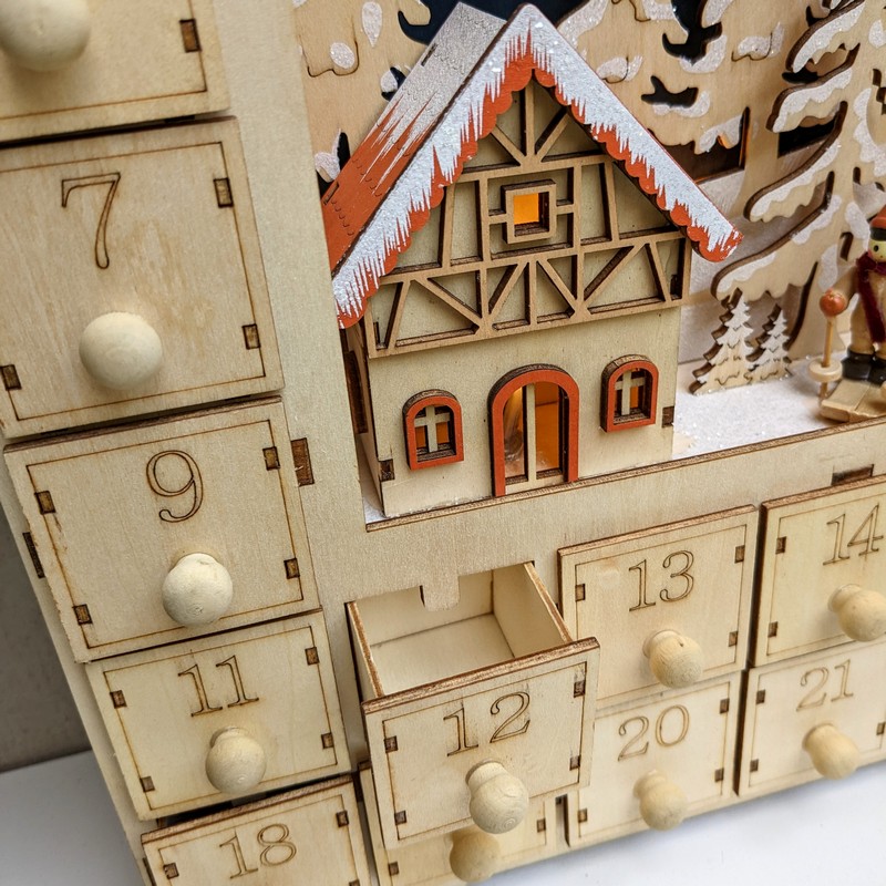 Calendario dell'avvento a forma di casetta in legno con cassetti e illuminazione